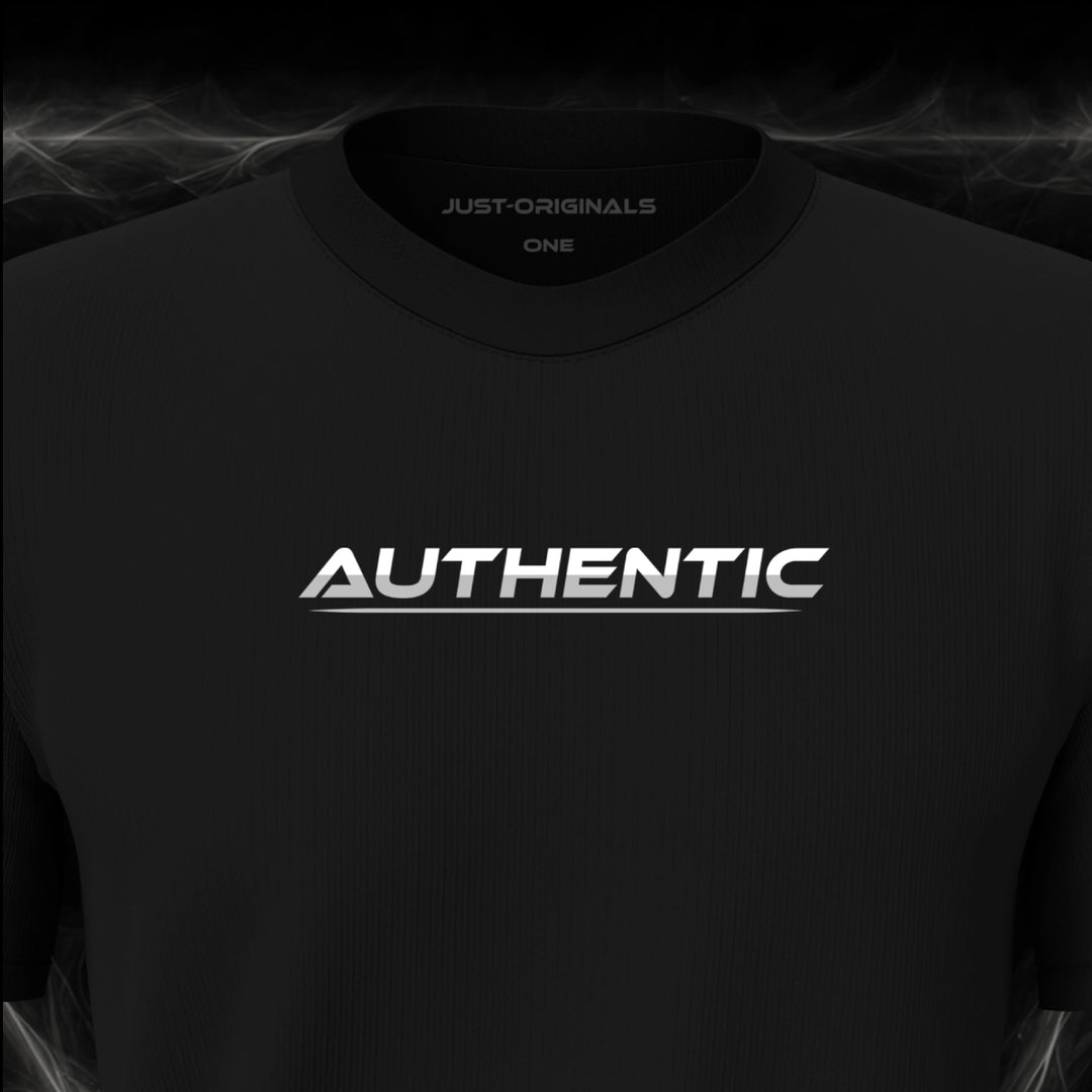 Close-up of the JUST-ORIGINALS™ LIFESTYLE ONE Unisex AUTHENTIC III design on a BlackPulse™ premium black t-shirt, featuring white AUTHENTIC typography with silver-gray accent, silver-gray underline, and premium neck label.