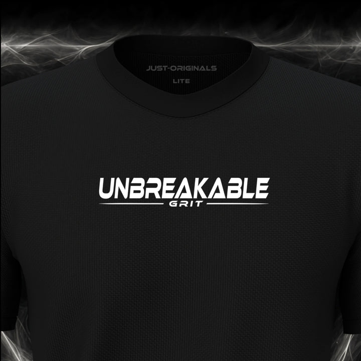 Close-up of the JUST-ORIGINALS™ MAXPULSE™ LITE Men UNBREAKABLE GRIT design on a BlackPulse™ performance t-shirt, featuring white UNBREAKABLE typography, white GRIT text, a white underline, and premium neck label.