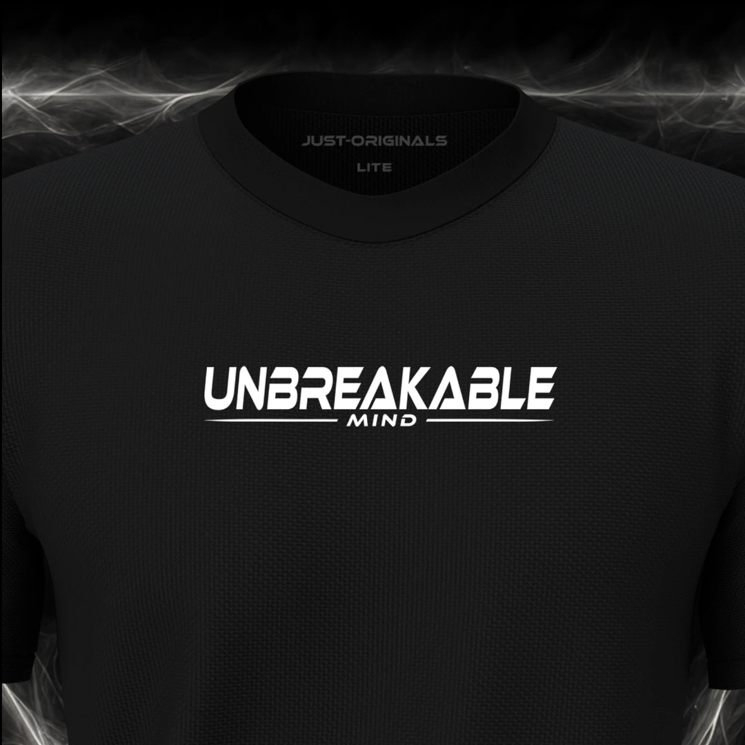 Close-up of the JUST-ORIGINALS™ MAXPULSE™ LITE Men UNBREAKABLE MIND design on a BlackPulse™ performance t-shirt, featuring white UNBREAKABLE typography, white MIND text, a white underline, and premium neck label.