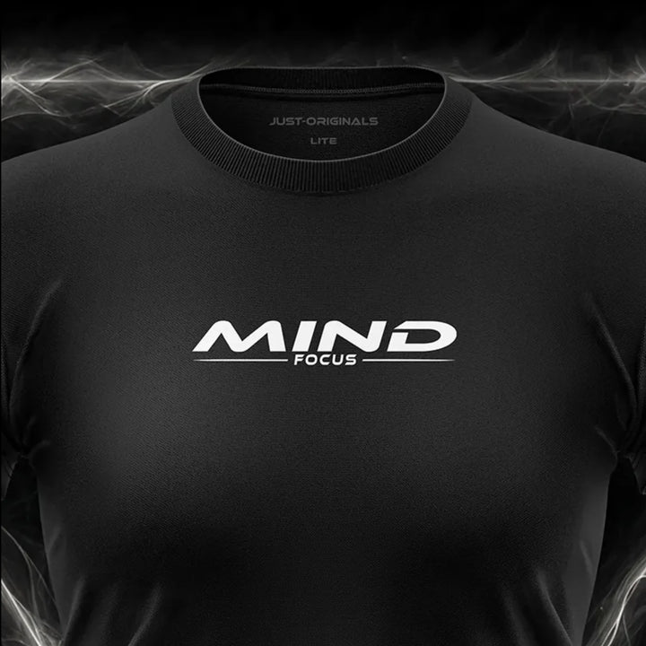 Close-up of the JUST-ORIGINALS™ MAXPULSE™ LITE Women MIND FOCUS design on a BlackPulse™ performance t-shirt, featuring white and silver MIND typography, white FOCUS text, white accent line, silver premium neck label, and premium athletic fabric.