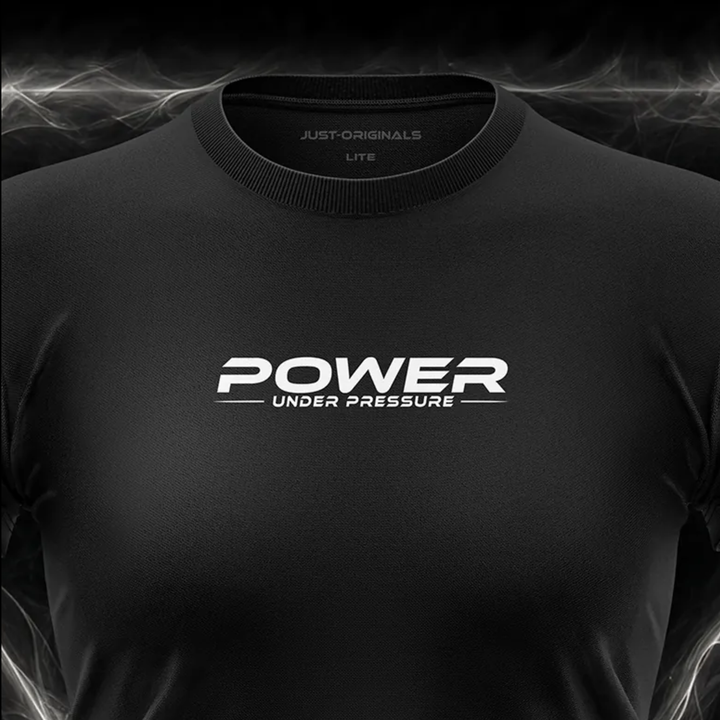 Close-up of the JUST-ORIGINALS™ MAXPULSE™ LITE Women POWER UNDER PRESSURE design on a BlackPulse™ performance t-shirt, featuring white and silver POWER typography, white UNDER PRESSURE text, white accent line, silver premium neck label, and premium athletic fabric.