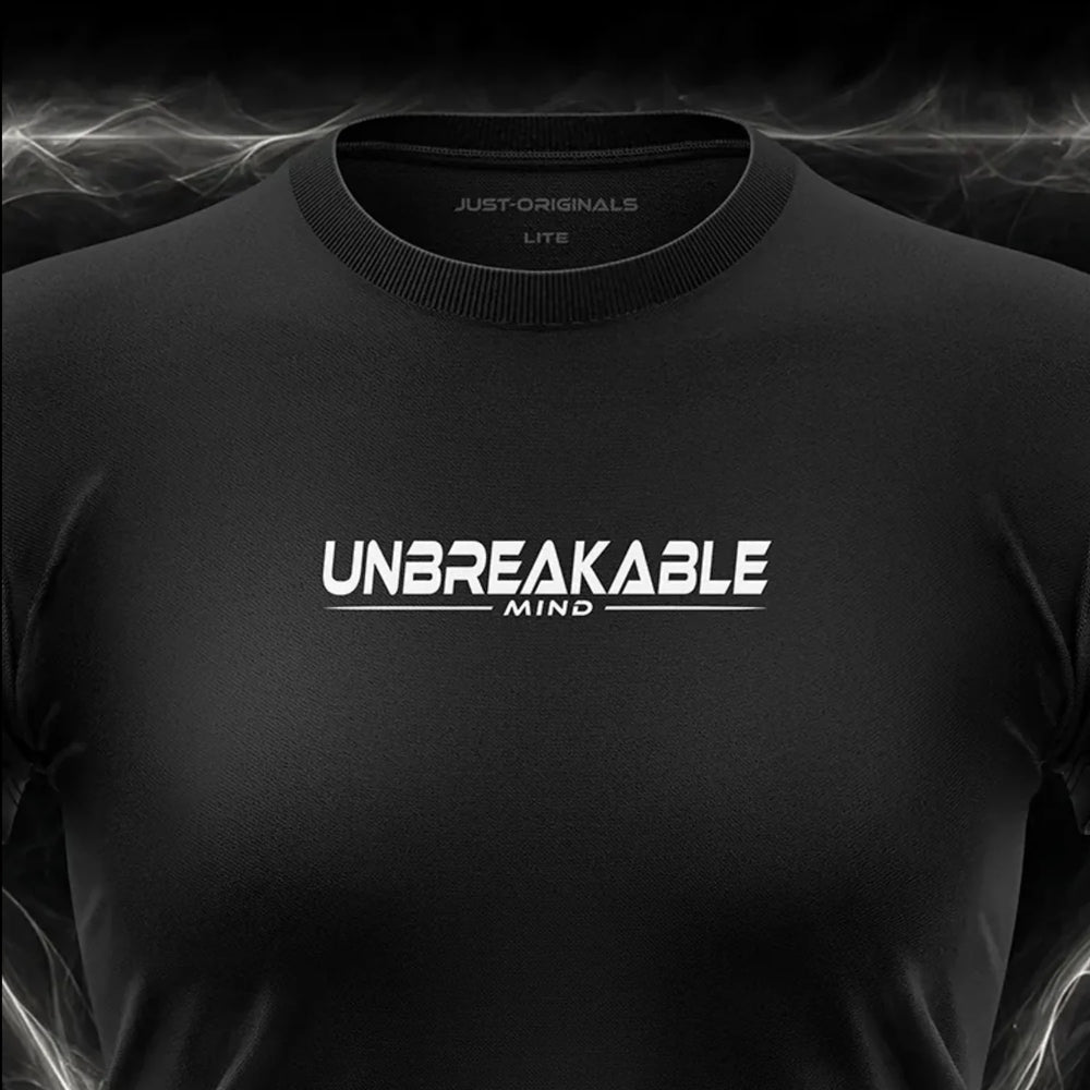 Close-up of the JUST-ORIGINALS™ MAXPULSE™ LITE Women UNBREAKABLE MIND design on a BlackPulse™ performance t-shirt, featuring white and silver UNBREAKABLE typography, white MIND text, white accent line, silver premium neck label, and premium athletic fabric.