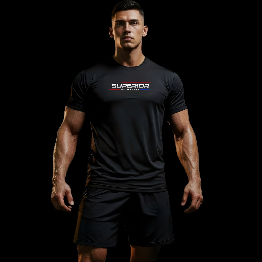 MAXPULSE™ Men | Superior by Design Performance Tee | Athletic male fitness model wearing black MAXPULSE™ training shirt with SUPERIOR BY DESIGN chest print on a dark studio background | JUST-ORIGINALS™